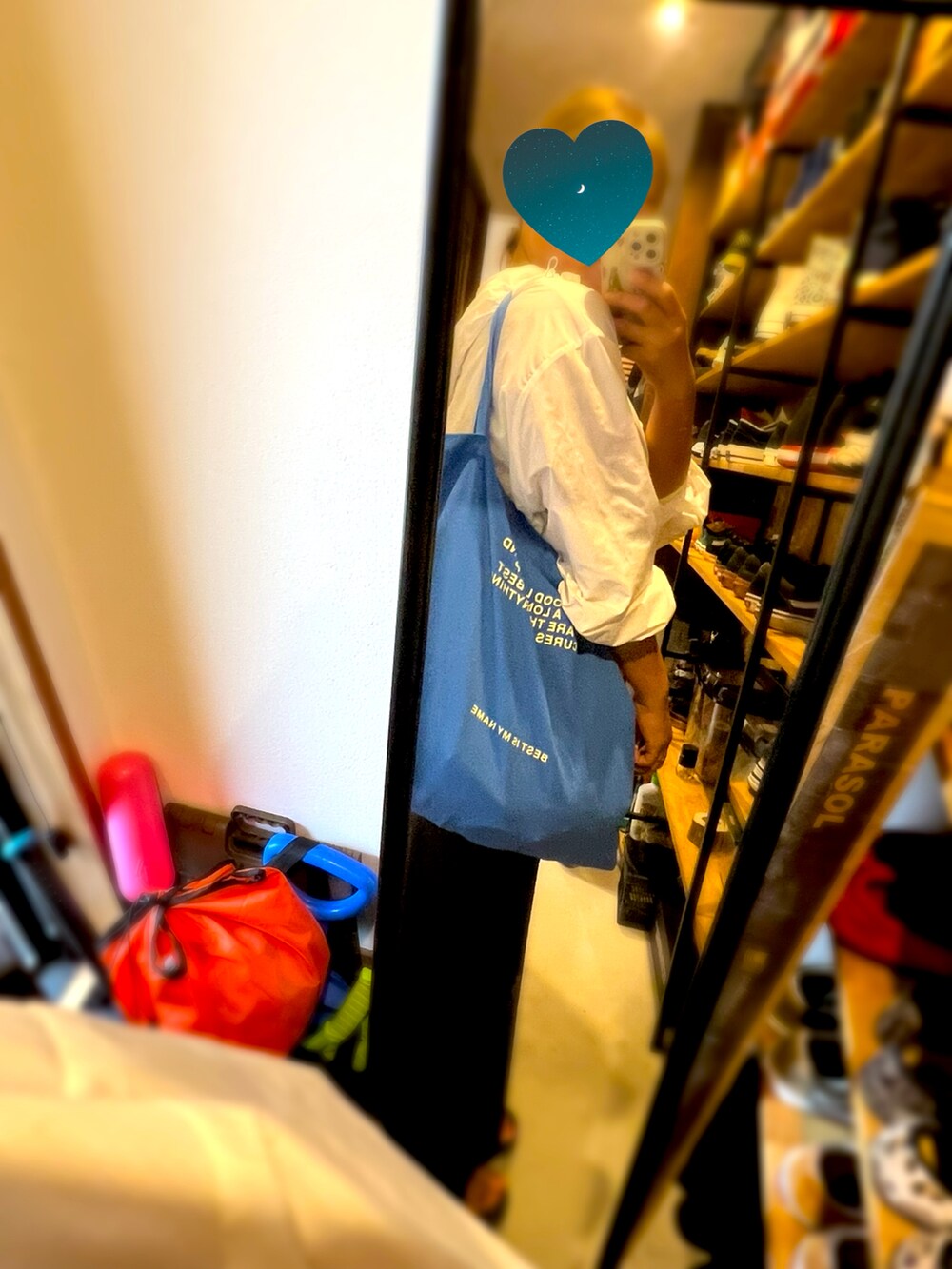 ブラック系のスカート、ブルー系のトートバッグ、ホワイト系のブルゾンを着用したレディースの夏コーディネートの2枚目の写真