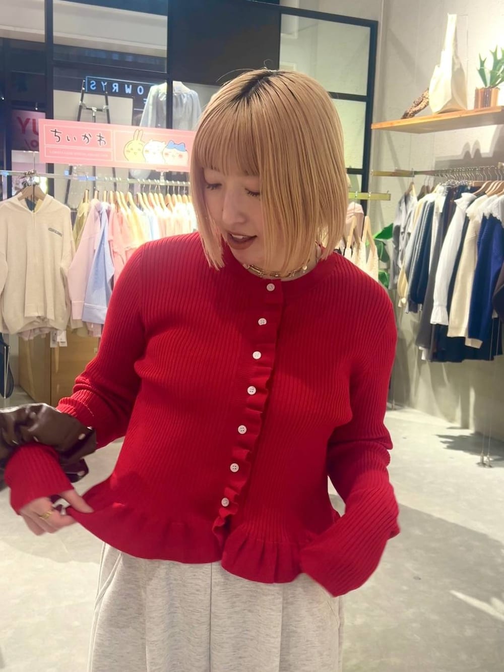 グレー系のスウェットパンツ、レッド系のTシャツ/カットソー、ブラウン系のヘアゴムを着用したレディースの冬コーディネートの3枚目の写真
