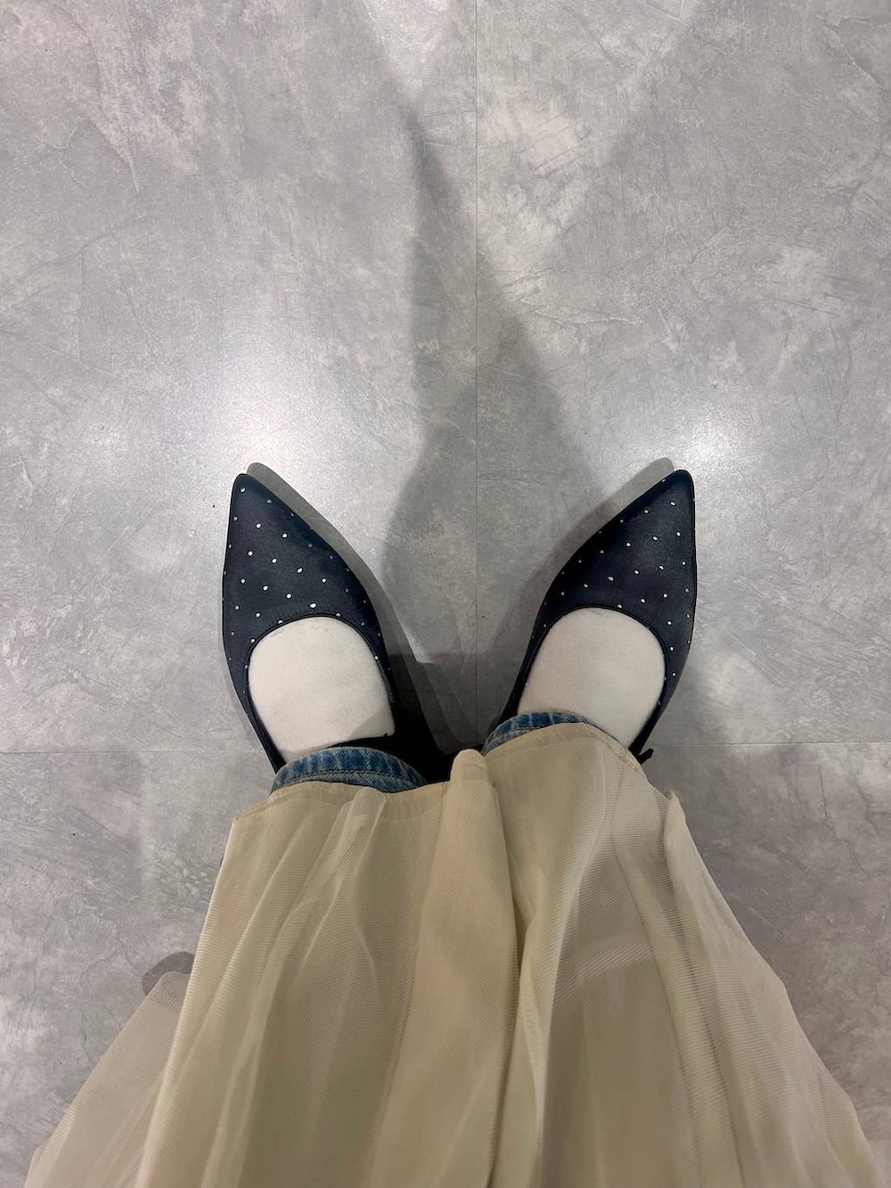 ブルー系のカーディガン/ボレロ、ブラック系のパンプス、ブルー系のデニムパンツを着用したレディースの冬コーディネートの7枚目の写真