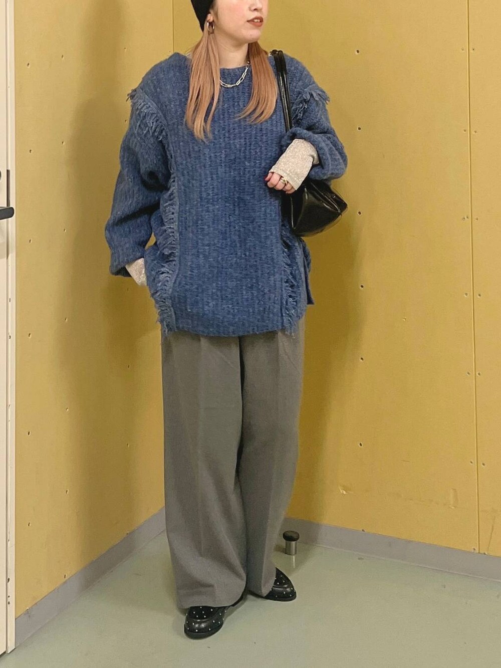 ブルー系のニット/セーター、ブラック系のショルダーバッグ、シルバー系のTシャツ/カットソーを着用したレディースの冬コーディネートの4枚目の写真