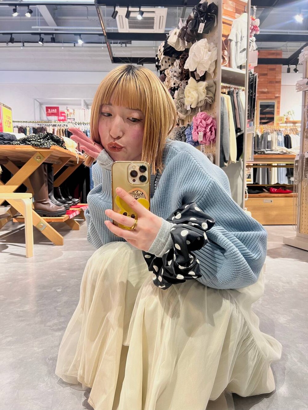 ブルー系のカーディガン/ボレロ、ブラック系のパンプス、ブルー系のデニムパンツを着用したレディースの冬コーディネートの2枚目の写真