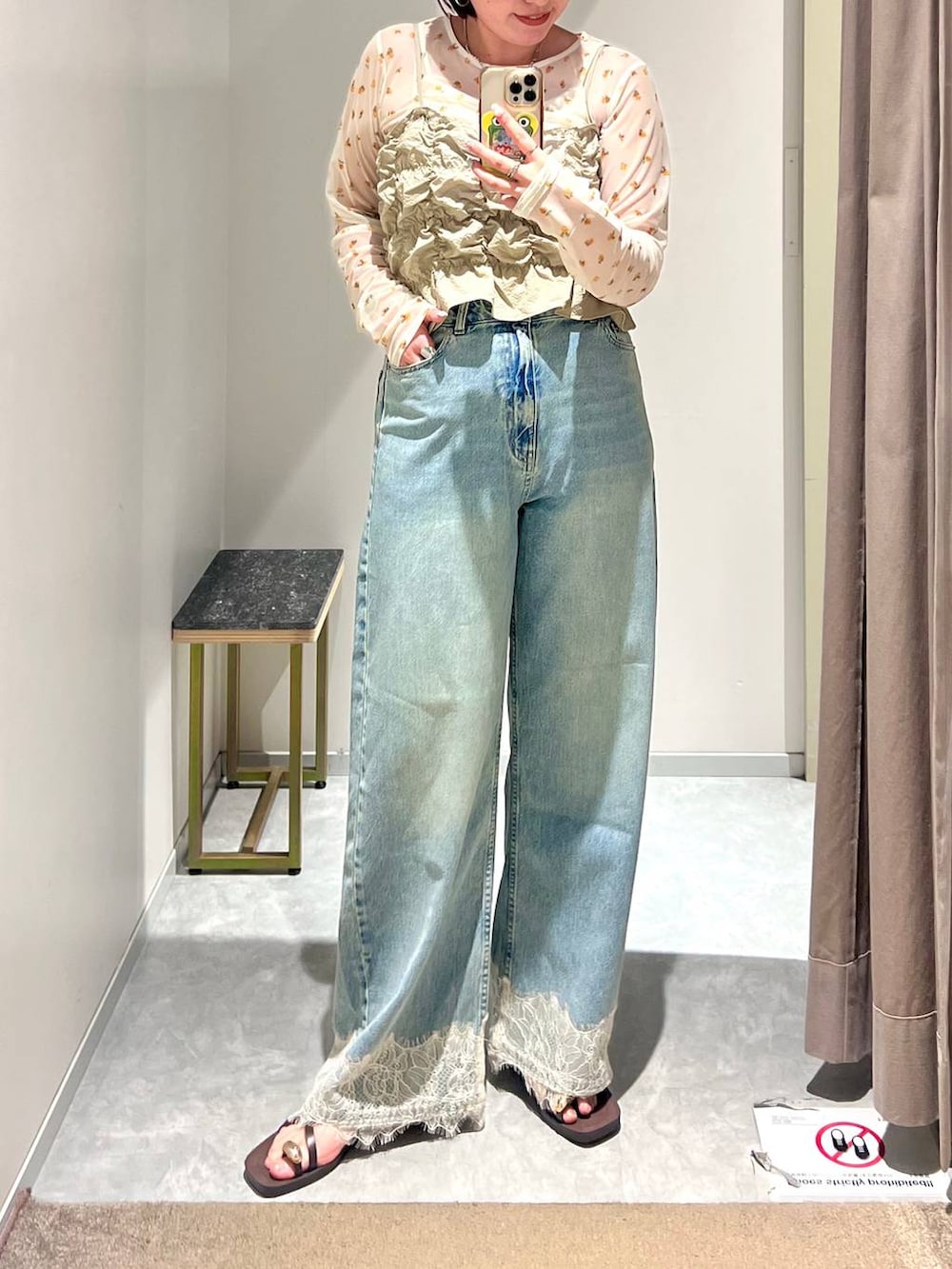 ベージュ系のベスト、ブルー系のデニムパンツ、ブラウン系のサンダルを着用したレディースの夏コーディネートの2枚目の写真
