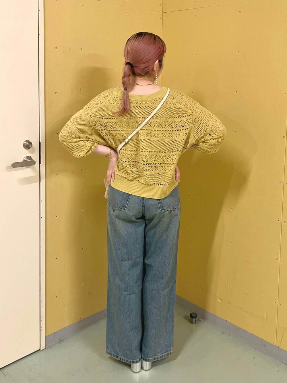 ベージュ系のショルダーバッグ、イエロー系のカーディガン/ボレロ、シルバー系のサンダルを着用したレディースの夏コーディネートの3枚目の写真