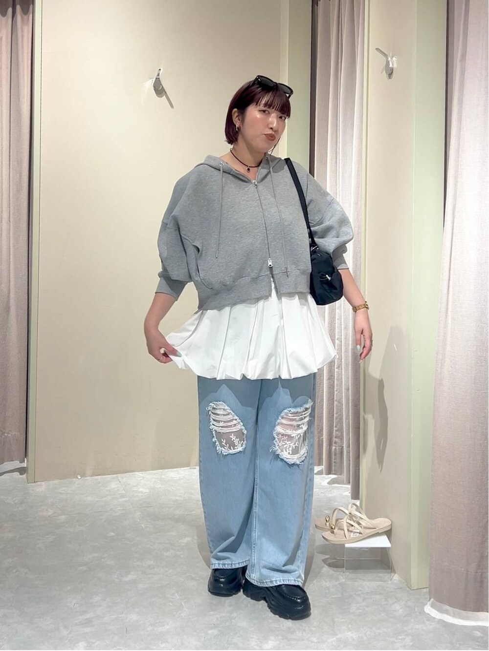 グレー系のパーカー、ブルー系のデニムパンツ、ブラック系のローファーを着用したレディースの秋コーディネートの7枚目の写真
