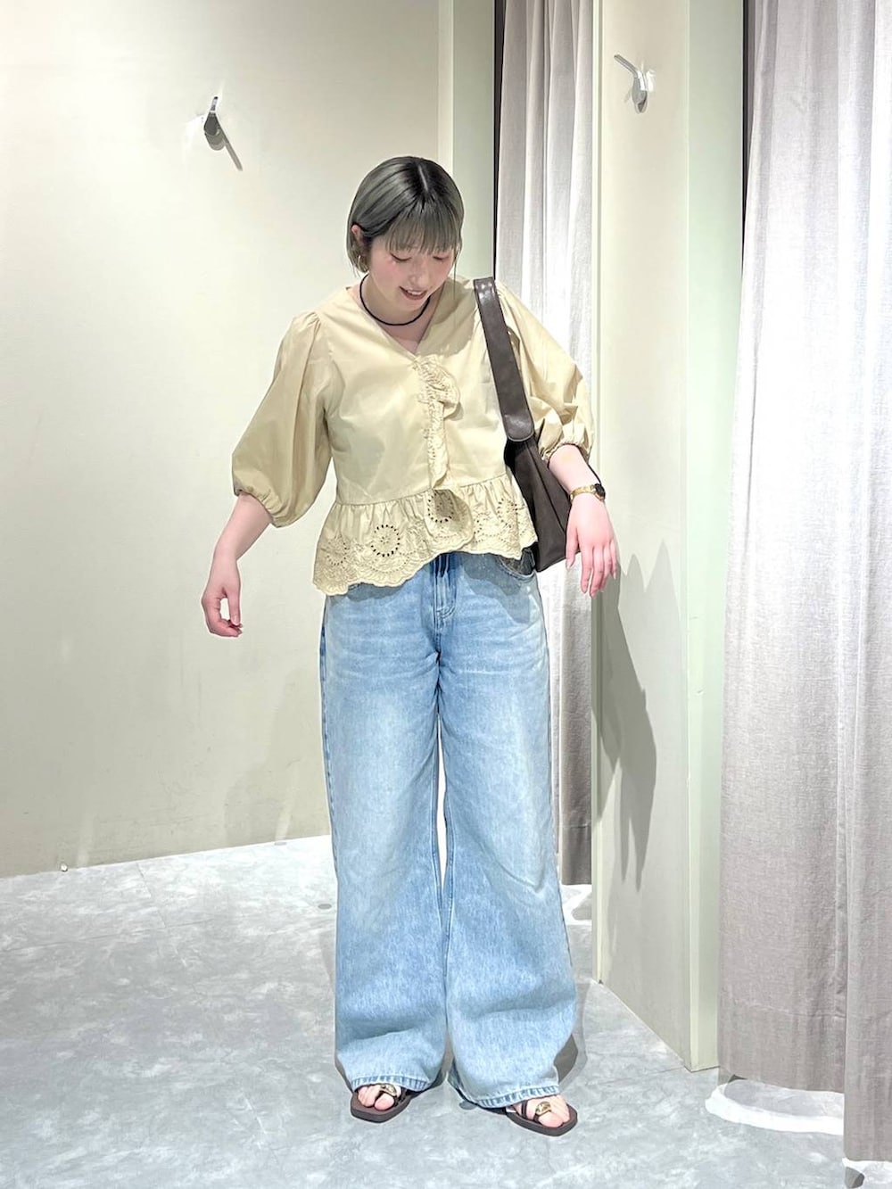 ブルー系のデニムパンツ、ブラウン系のサンダル、ベージュ系のシャツ/ブラウスを着用したレディースの春コーディネートの3枚目の写真