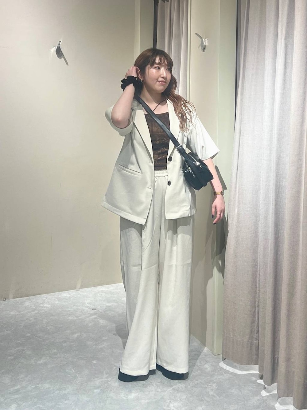 ホワイト系のテーラードジャケット、ホワイト系のその他パンツ、ブラック系のサンダルを着用したレディースの夏コーディネートの5枚目の写真