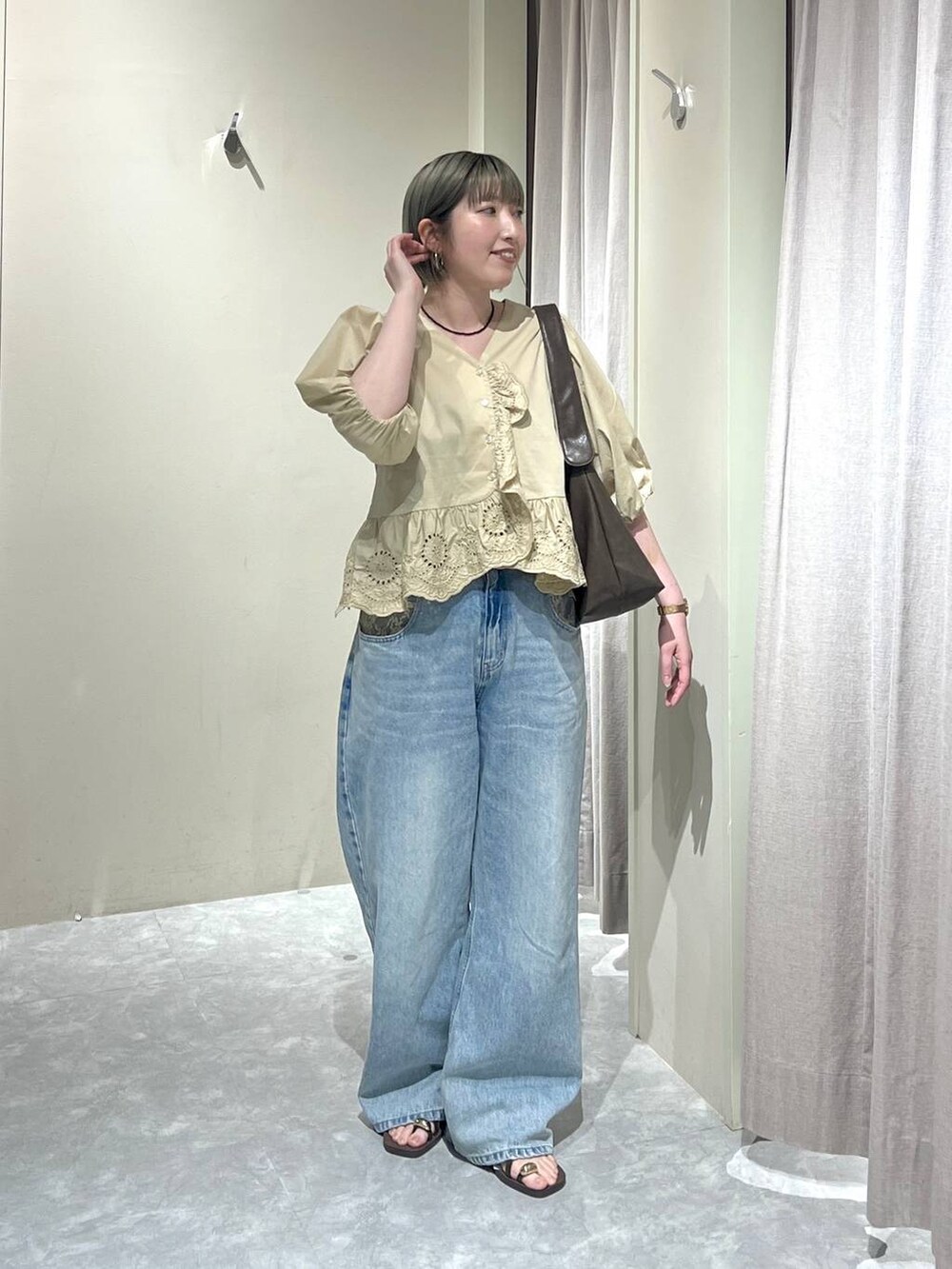 ブルー系のデニムパンツ、ブラウン系のサンダル、ベージュ系のシャツ/ブラウスを着用したレディースの春コーディネートの8枚目の写真