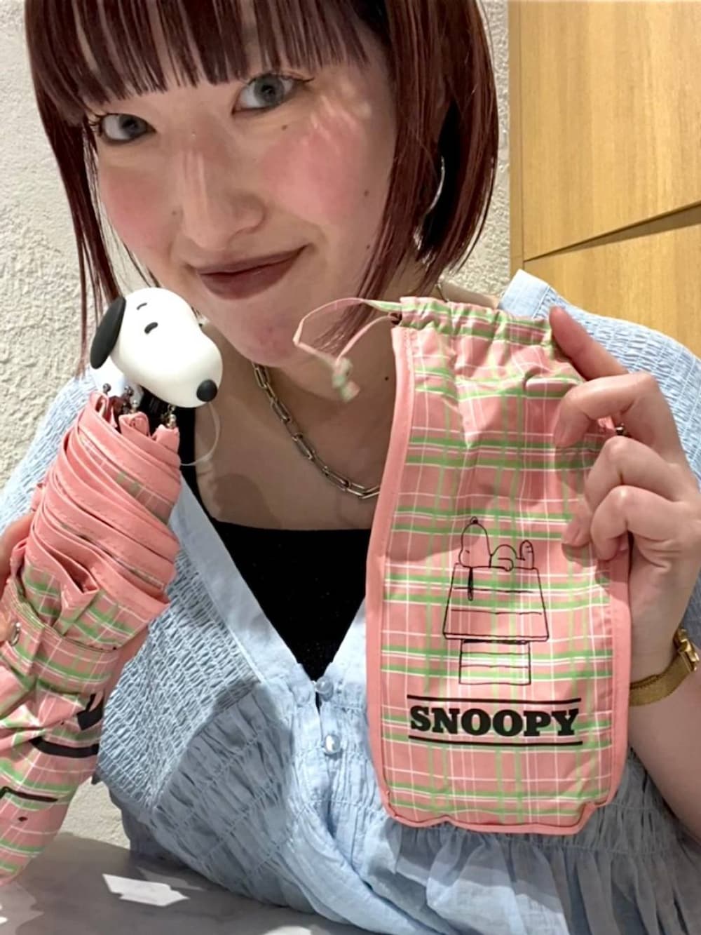 ブラック系のタンクトップ、ブルー系のシャツ/ブラウス、ピンク系の折りたたみ傘を着用したレディースの夏コーディネートの4枚目の写真