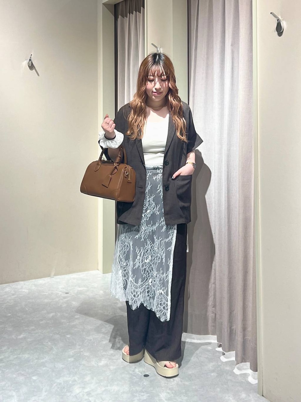 ホワイト系のTシャツ/カットソー、ホワイト系のサンダル、ブラウン系のテーラードジャケットを着用したレディースの秋コーディネートの6枚目の写真