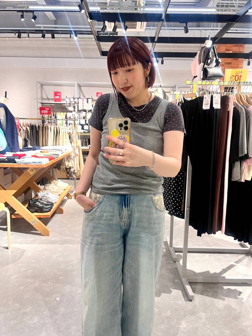 グレー系のタンクトップ、ブルー系のデニムパンツ、ブラック系のローファーを着用したレディースの夏コーディネートの8枚目の写真