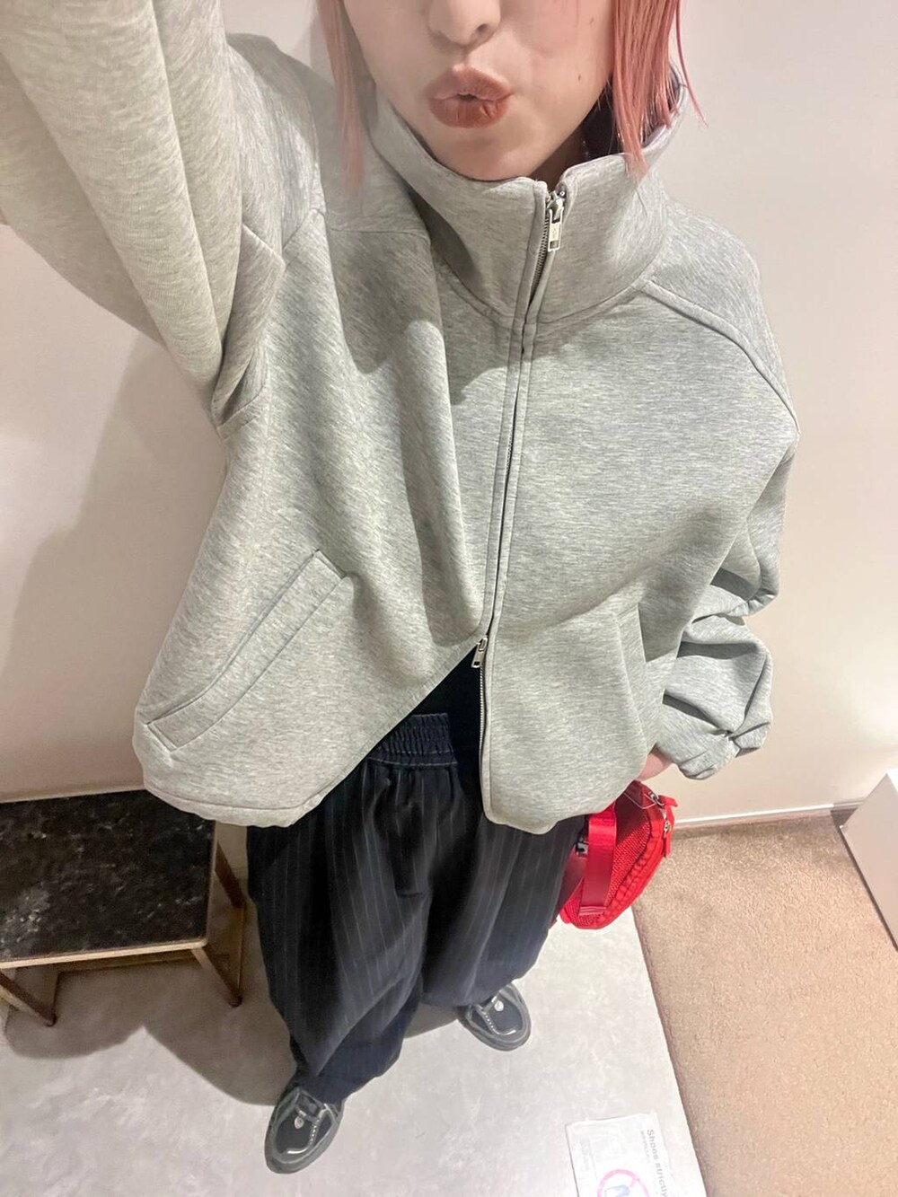 ブルー系のその他パンツ、レッド系のボディバッグ/ウエストポーチ、グレー系のスウェットを着用したレディースの春コーディネートの4枚目の写真