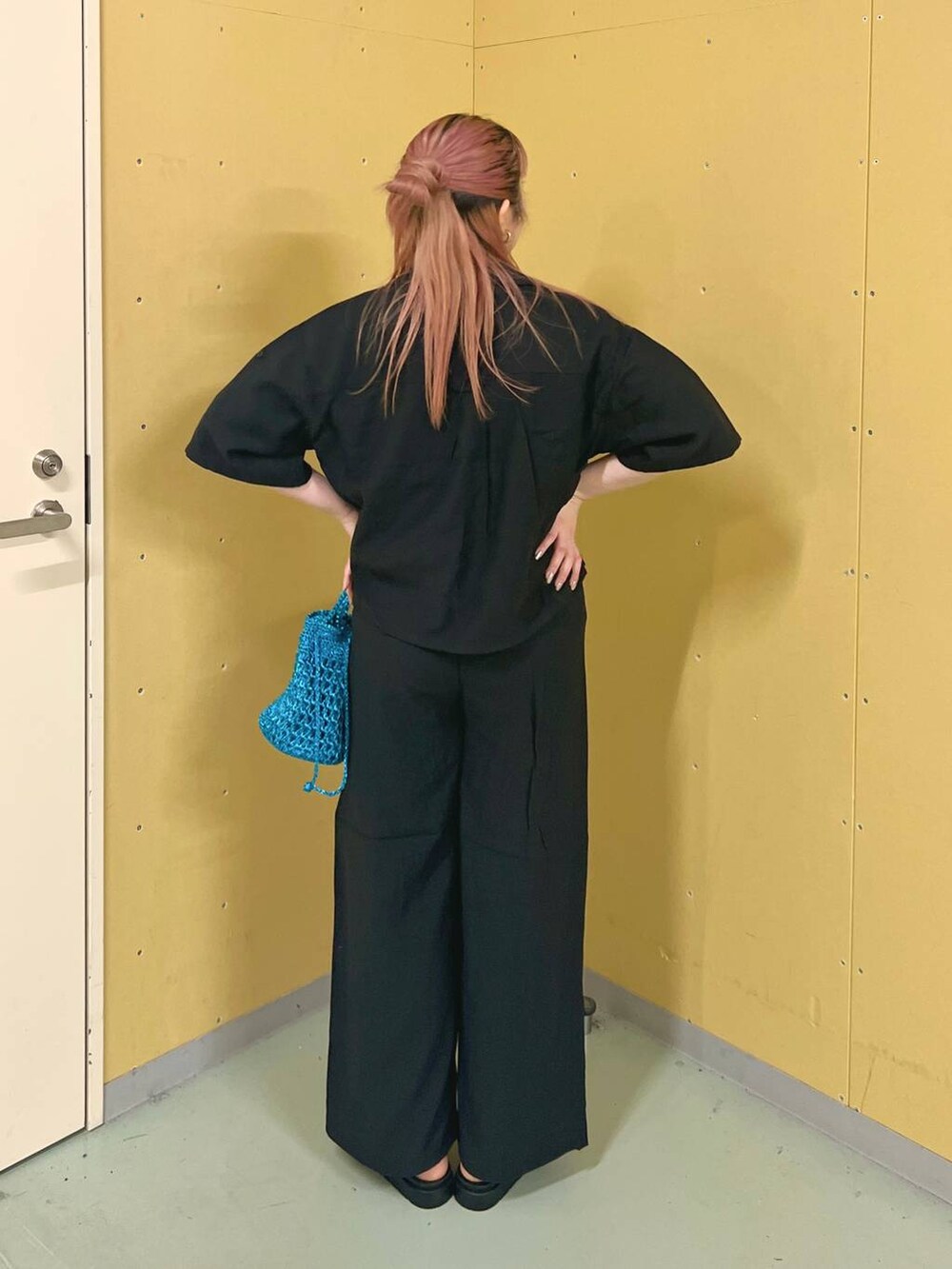 ブラック系のスニーカー、ホワイト系のTシャツ/カットソー、ブルー系のショルダーバッグを着用したレディースの春コーディネートの3枚目の写真