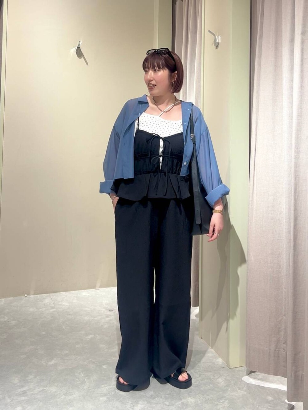 ブラック系のショルダーバッグ、ブルー系のシャツ/ブラウス、ブラック系のサンダルを着用したレディースの夏コーディネートの5枚目の写真