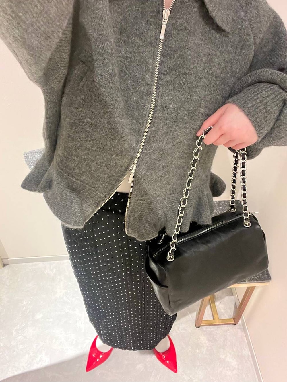 レッド系のパンプス、ブラック系のショルダーバッグ、ブラック系のスカートを着用したレディースの冬コーディネートの4枚目の写真