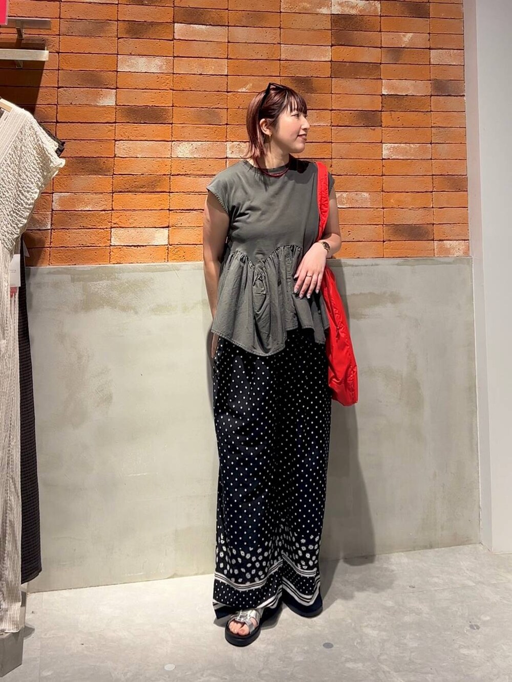グレー系のTシャツ/カットソー、シルバー系のサンダル、レッド系のショルダーバッグを着用したレディースの夏コーディネートの4枚目の写真