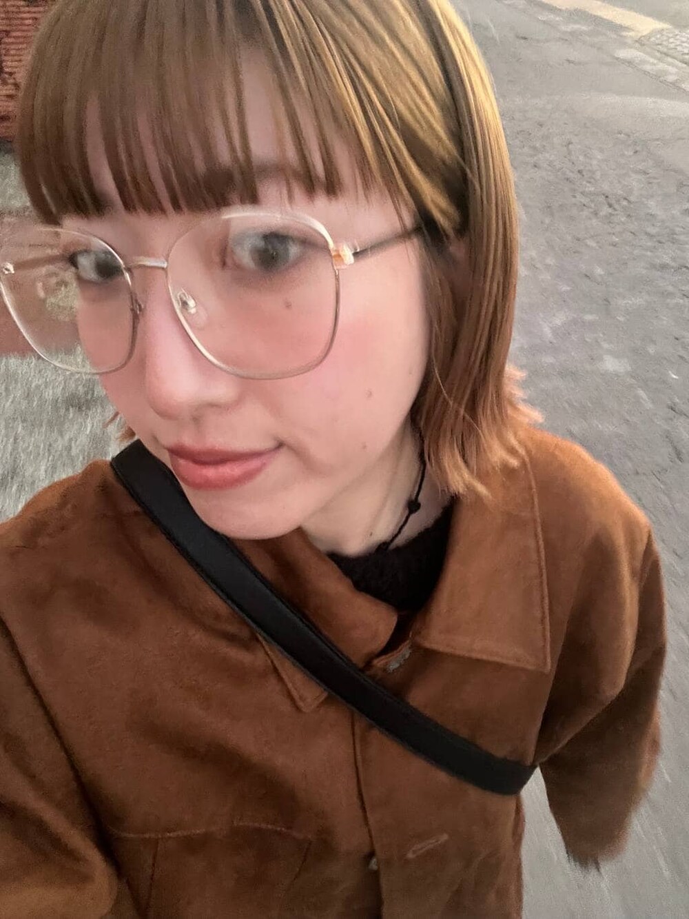 グレー系のスウェットパンツ、ブラウン系のブルゾン、ブラック系のショルダーバッグを着用したレディースの秋コーディネートの3枚目の写真