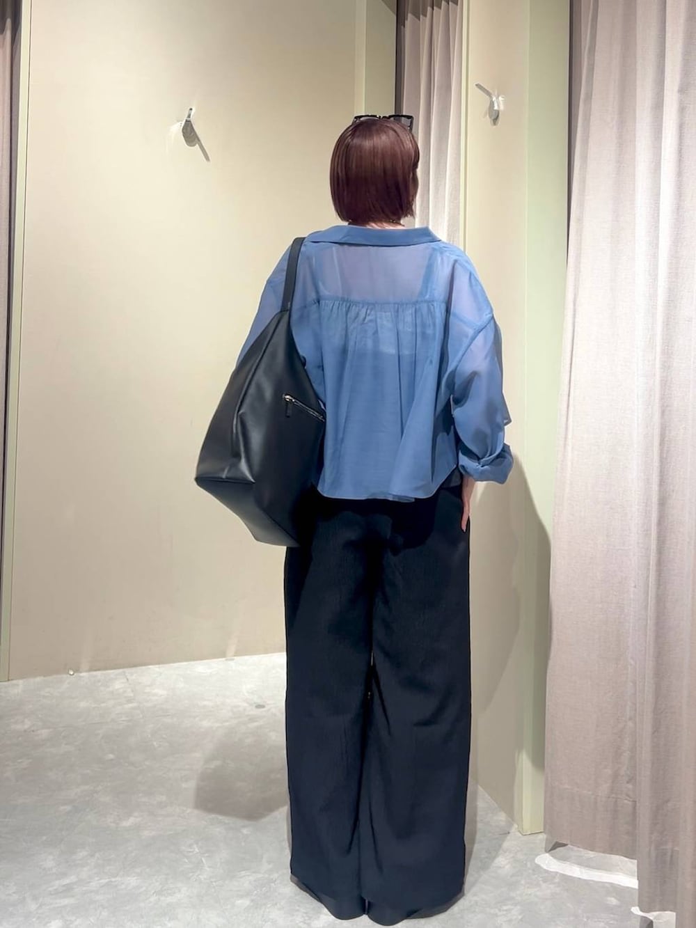 ブラック系のショルダーバッグ、ブルー系のシャツ/ブラウス、ブラック系のサンダルを着用したレディースの夏コーディネートの3枚目の写真