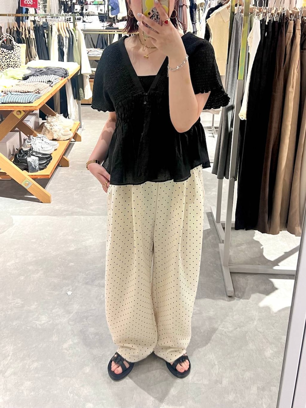 ホワイト系のスウェットパンツ、ブラック系のタンクトップ、ブラック系のサンダルを着用したレディースの夏コーディネートの2枚目の写真