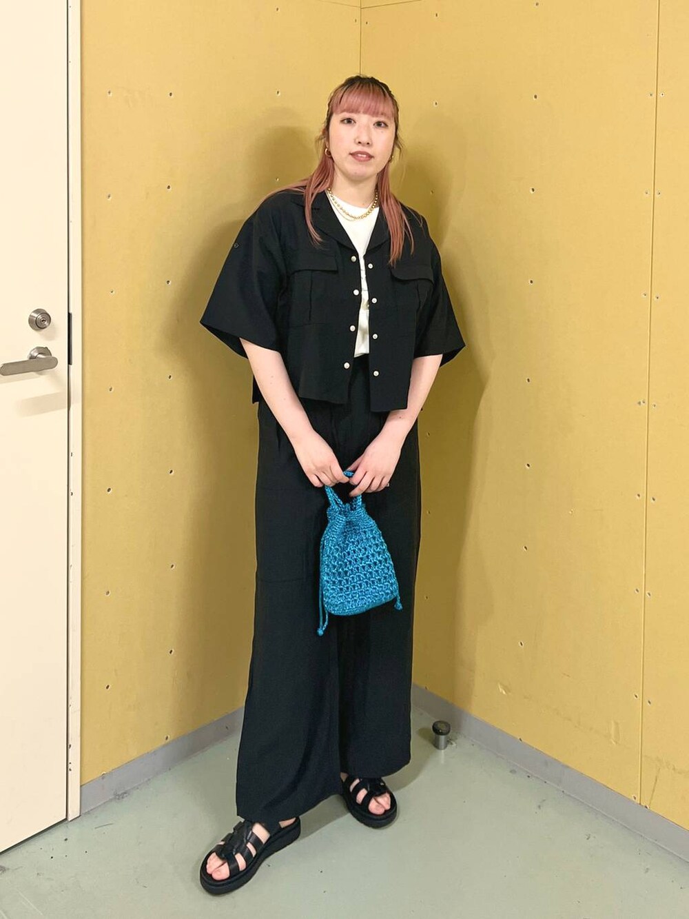 ブラック系のスニーカー、ホワイト系のTシャツ/カットソー、ブルー系のショルダーバッグを着用したレディースの春コーディネートの5枚目の写真