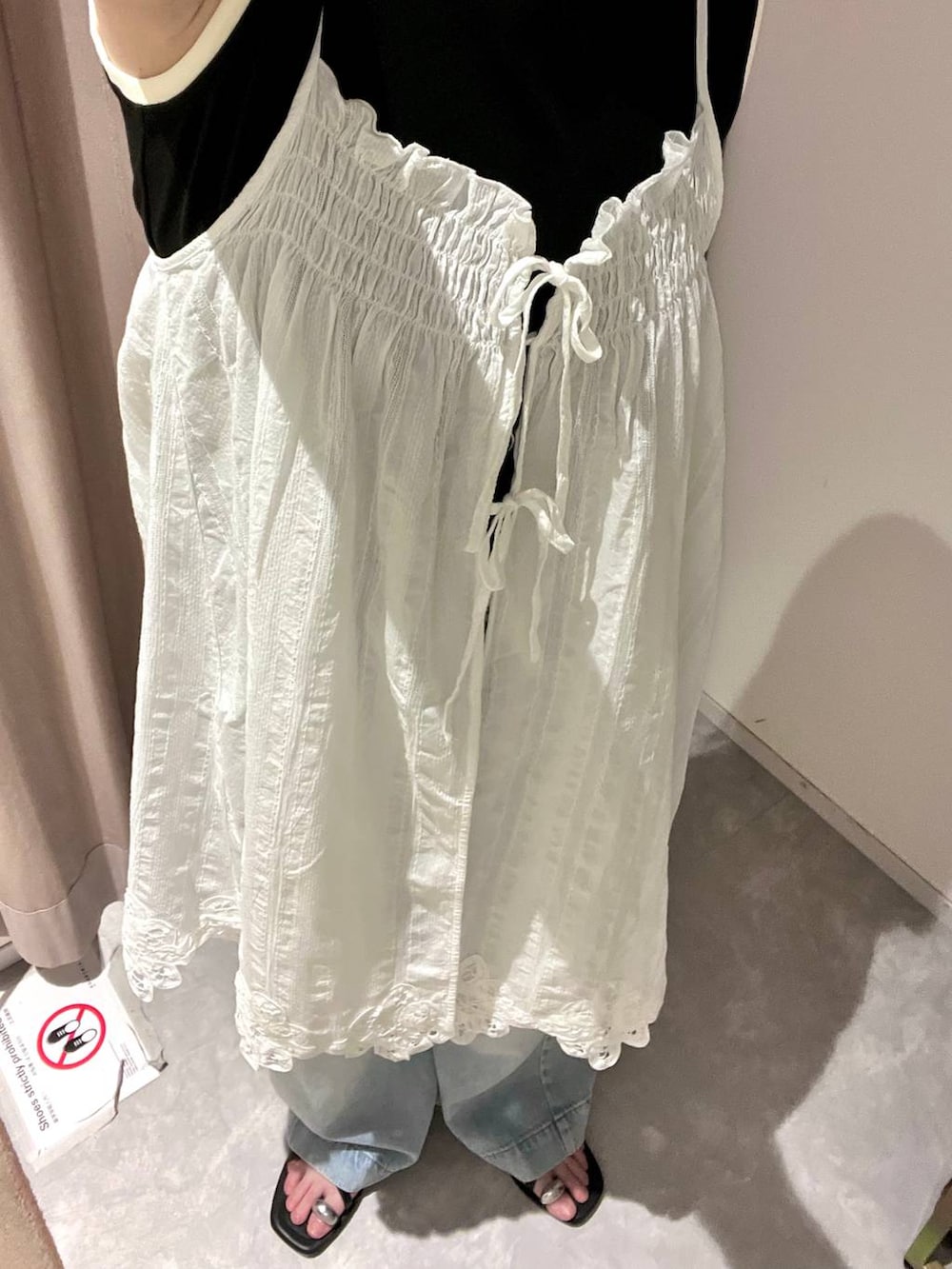 ブラック系のタンクトップ、ブルー系のデニムパンツ、ブラック系のサンダルを着用したレディースの夏コーディネートの2枚目の写真