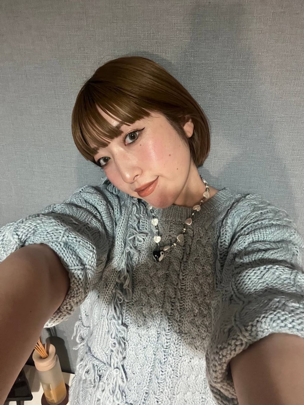 シルバー系のパンプス、ブラック系のデニムパンツ、ブルー系のニット/セーターを着用したレディースの秋コーディネートの3枚目の写真