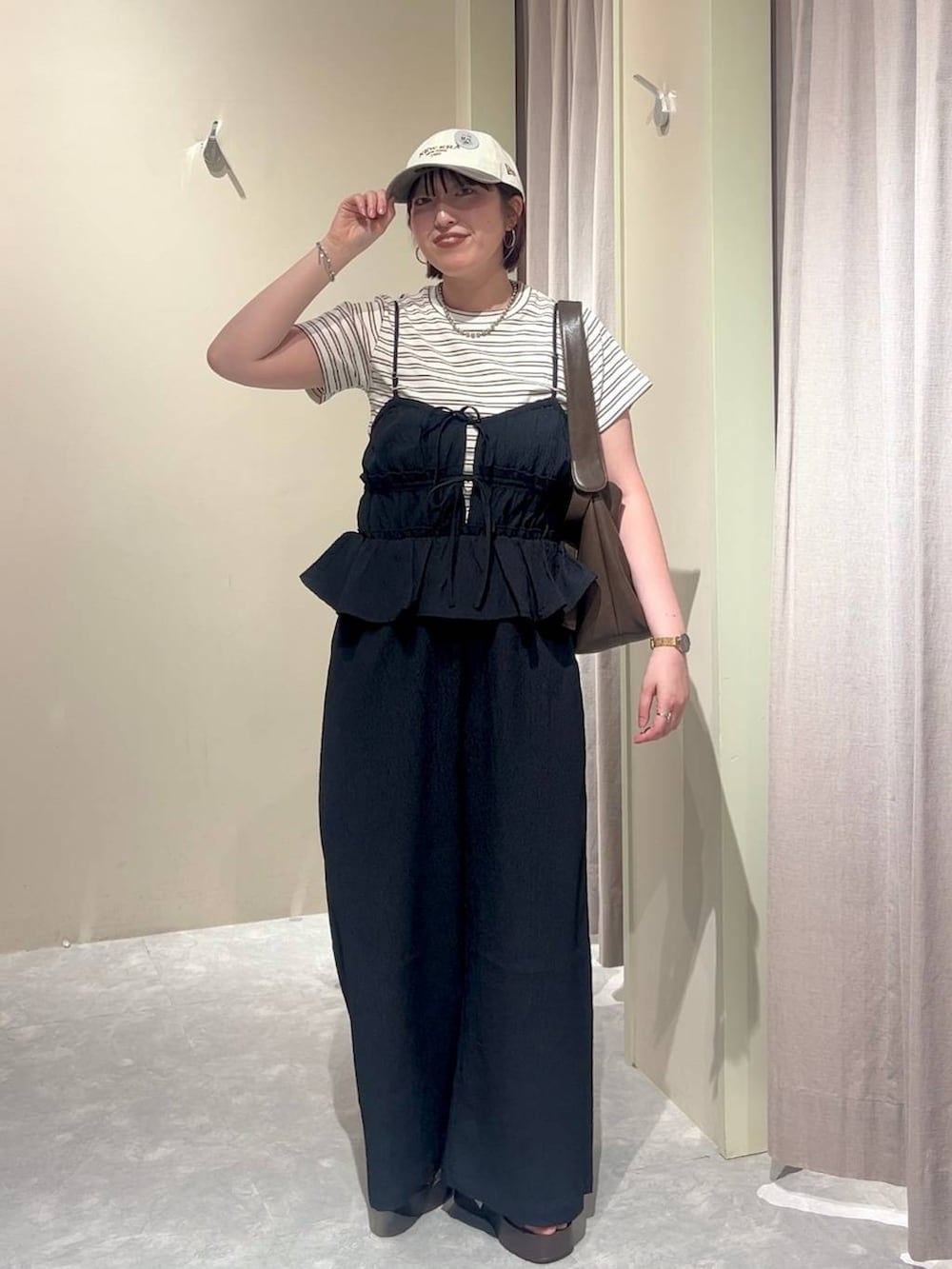 ホワイト系のTシャツ/カットソー、ブラウン系のサンダル、ブラウン系のショルダーバッグを着用したレディースの夏コーディネートの3枚目の写真