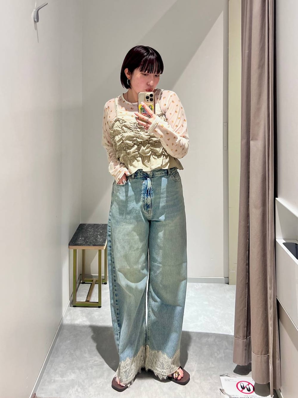 ベージュ系のベスト、ブルー系のデニムパンツ、ブラウン系のサンダルを着用したレディースの夏コーディネートの3枚目の写真