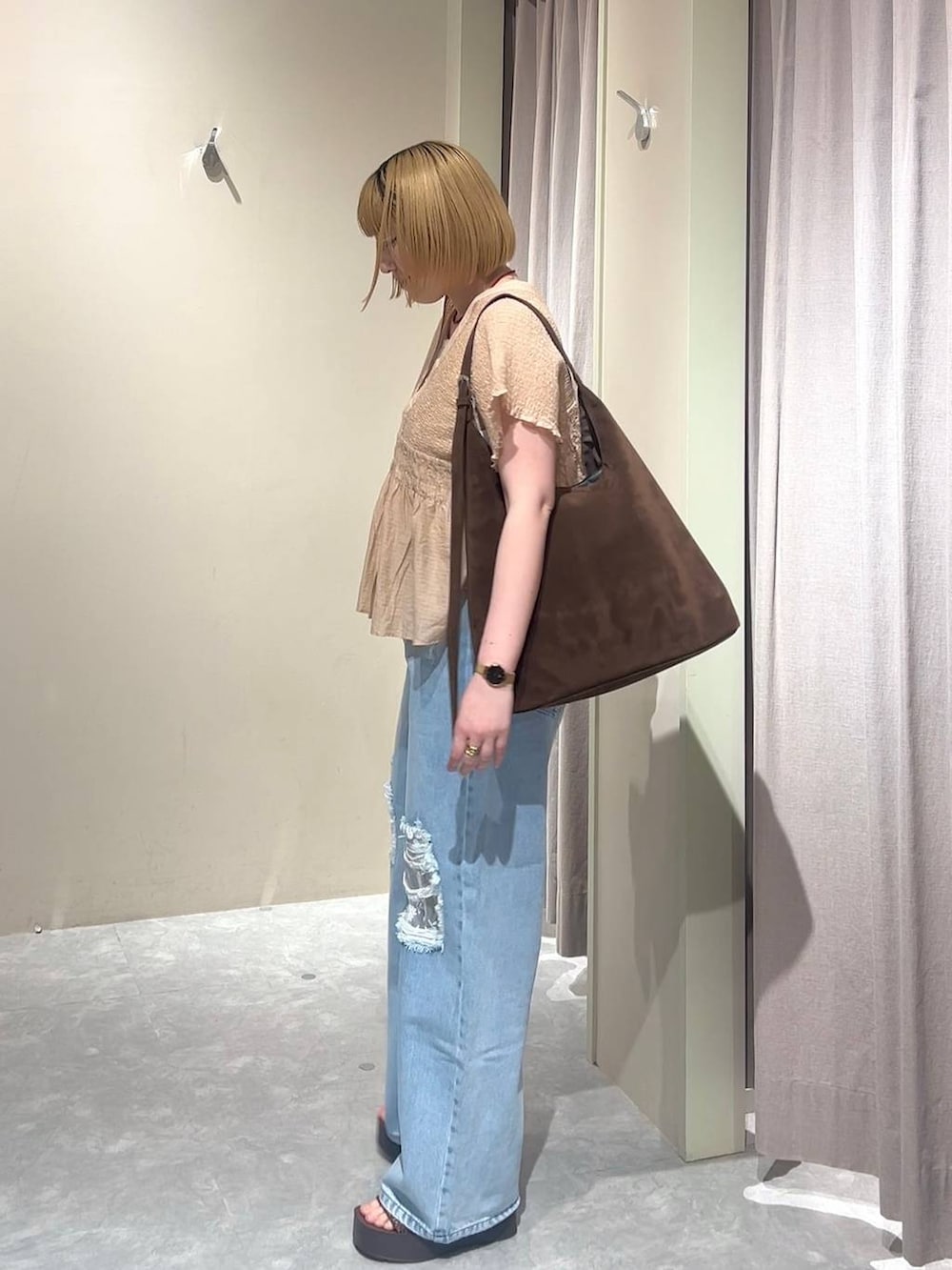 ブラウン系のショルダーバッグ、ブルー系のデニムパンツ、ブラウン系のサンダルを着用したレディースの春コーディネートの2枚目の写真