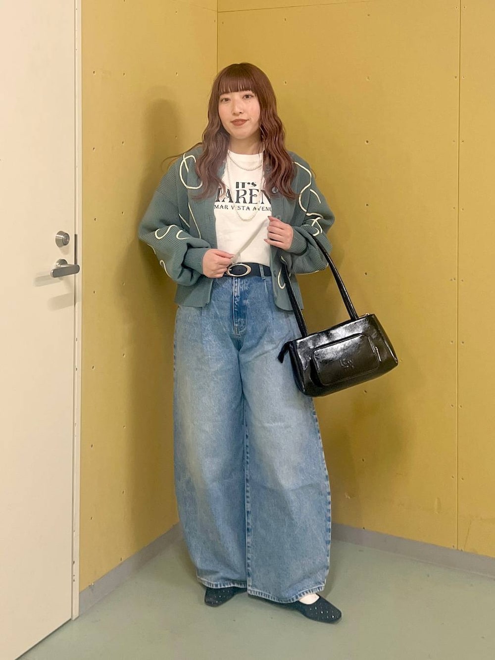 ブラック系のショルダーバッグ、ブルー系のデニムパンツ、ブルー系のカーディガン/ボレロを着用したレディースの冬コーディネートの3枚目の写真