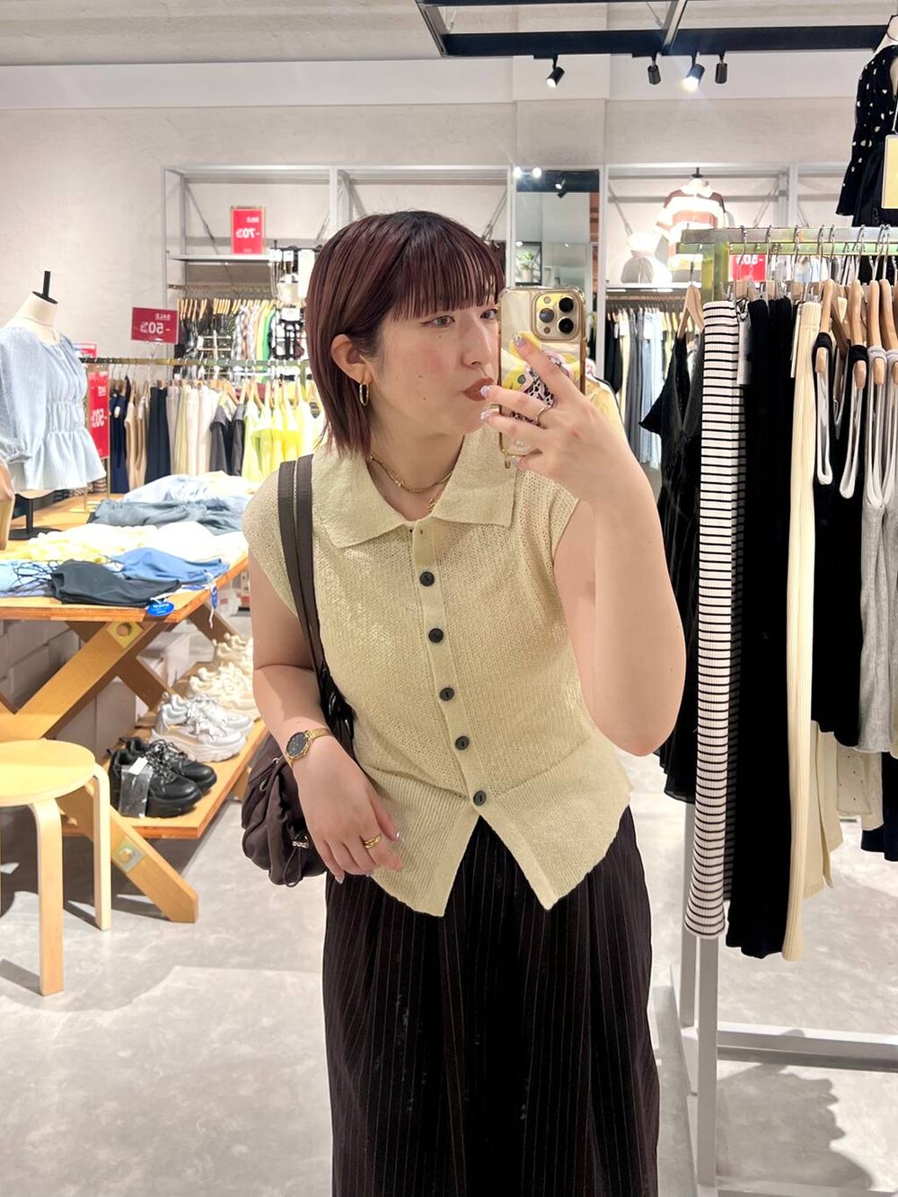 ホワイト系のベスト、ブラウン系のその他パンツ、ブラック系のサンダルを着用したレディースの夏コーディネートの6枚目の写真