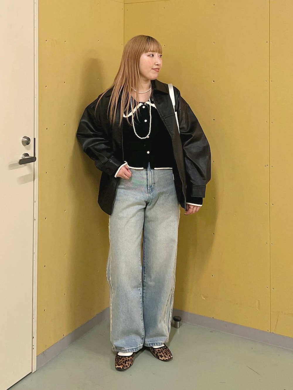 ブルー系のデニムパンツ、ブラウン系のバレエシューズ、シルバー系のトートバッグを着用したレディースの冬コーディネートの3枚目の写真