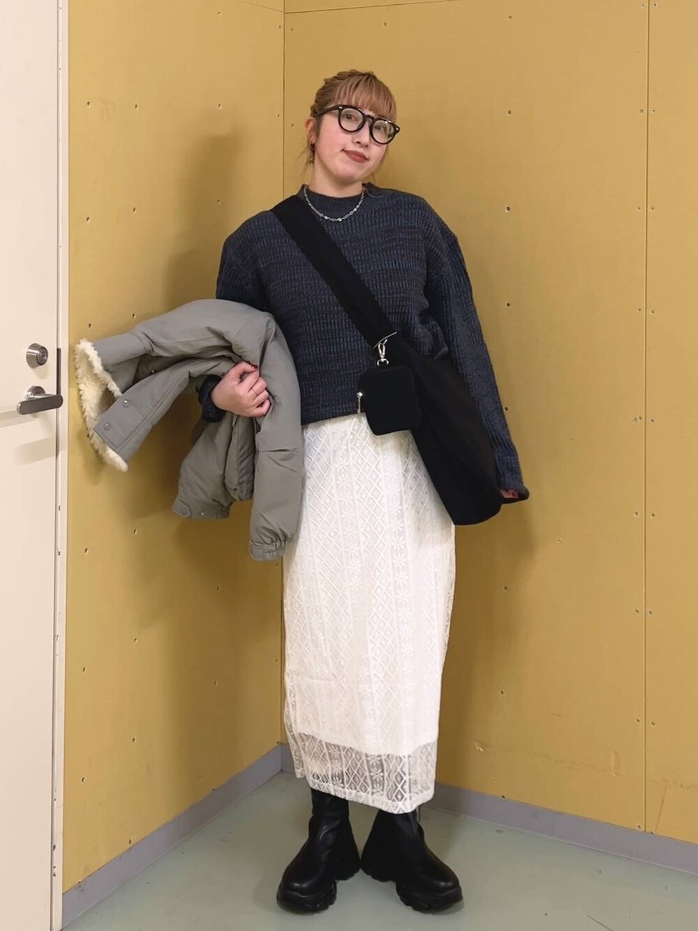 ブラック系のブーツ、ブルー系のワンピース、グリーン系のブルゾンを着用したレディースの冬コーディネートの8枚目の写真