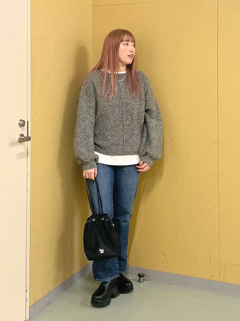 ブルー系のデニムパンツ、ブラック系のブーツ、ホワイト系のTシャツ/カットソーを着用したレディースの冬コーディネートの5枚目の写真