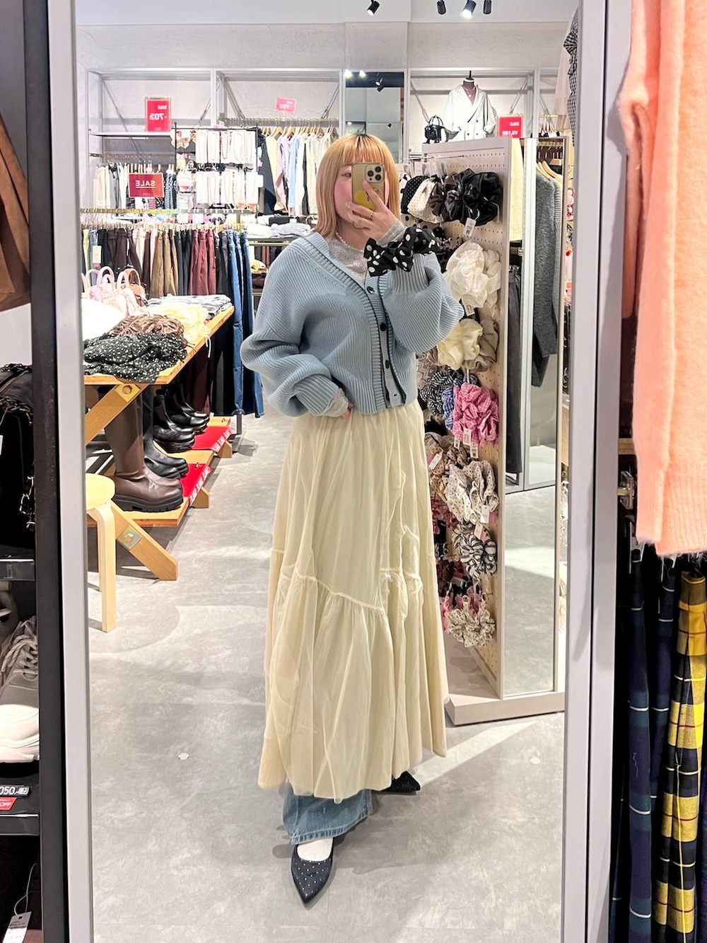 ブルー系のカーディガン/ボレロ、ブラック系のパンプス、ブルー系のデニムパンツを着用したレディースの冬コーディネートの4枚目の写真