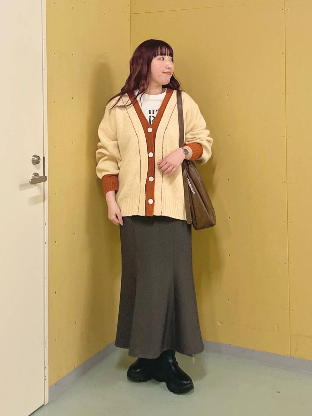 ブラック系のブーツ、ブラウン系のショルダーバッグ、グレー系のスカートを着用したレディースの冬コーディネートの4枚目の写真