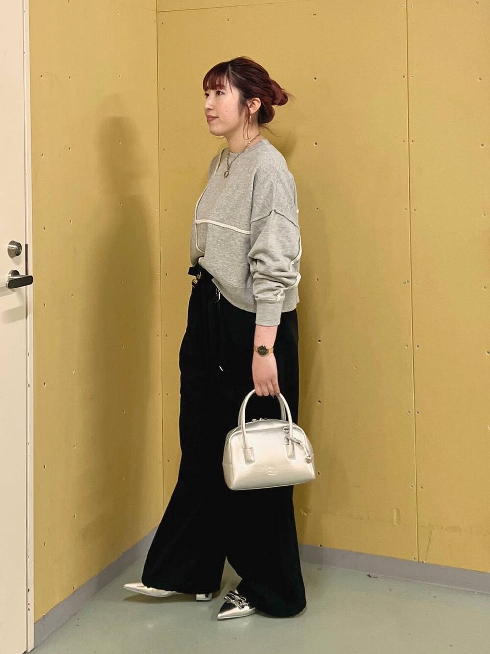 ブラック系のワンピース、シルバー系のパンプス、シルバー系のボストンバッグを着用したレディースの秋コーディネートの2枚目の写真