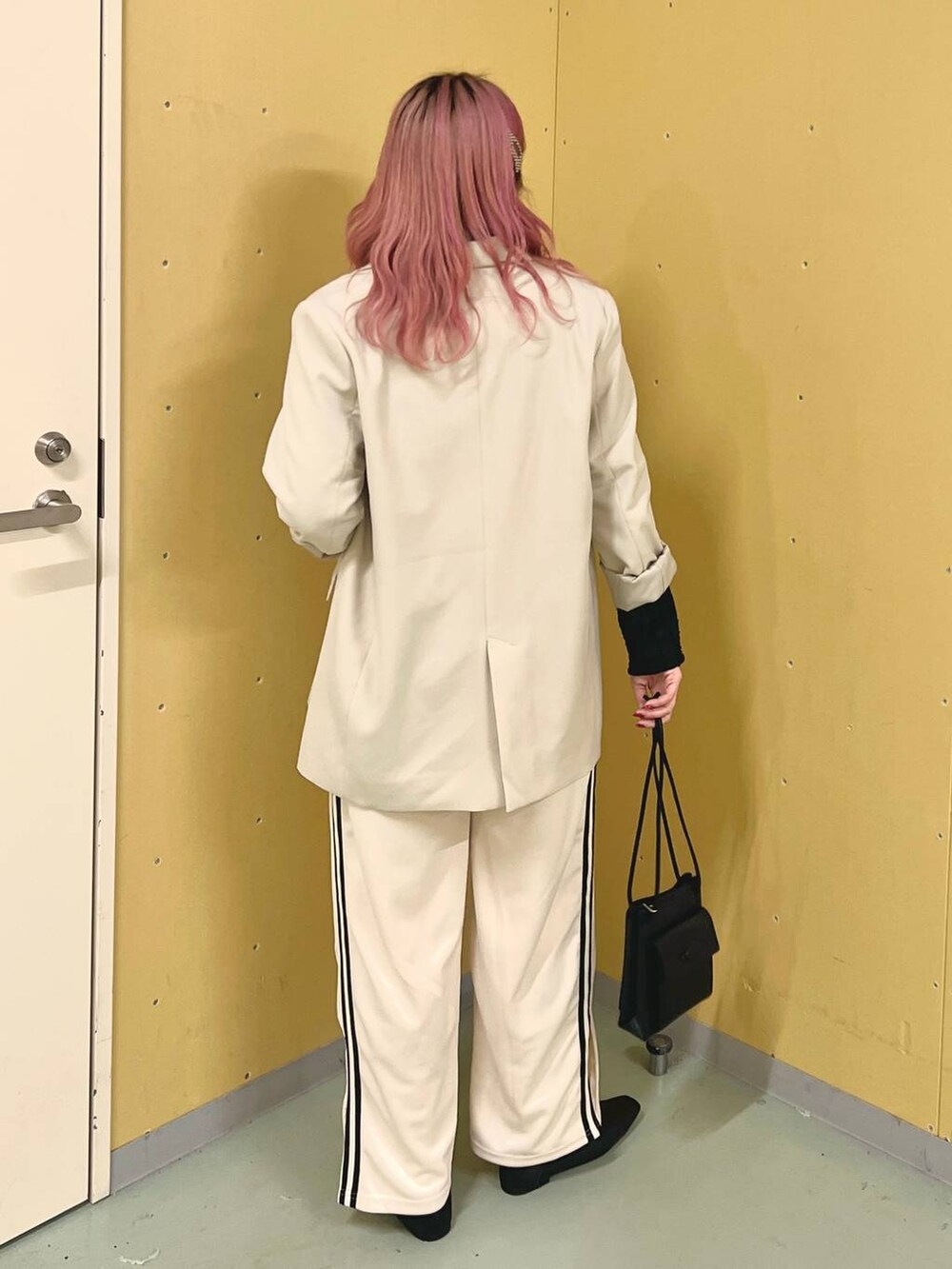ブラック系のパンプス、ブラック系のTシャツ/カットソー、ホワイト系のスウェットパンツを着用したレディースの春コーディネートの3枚目の写真