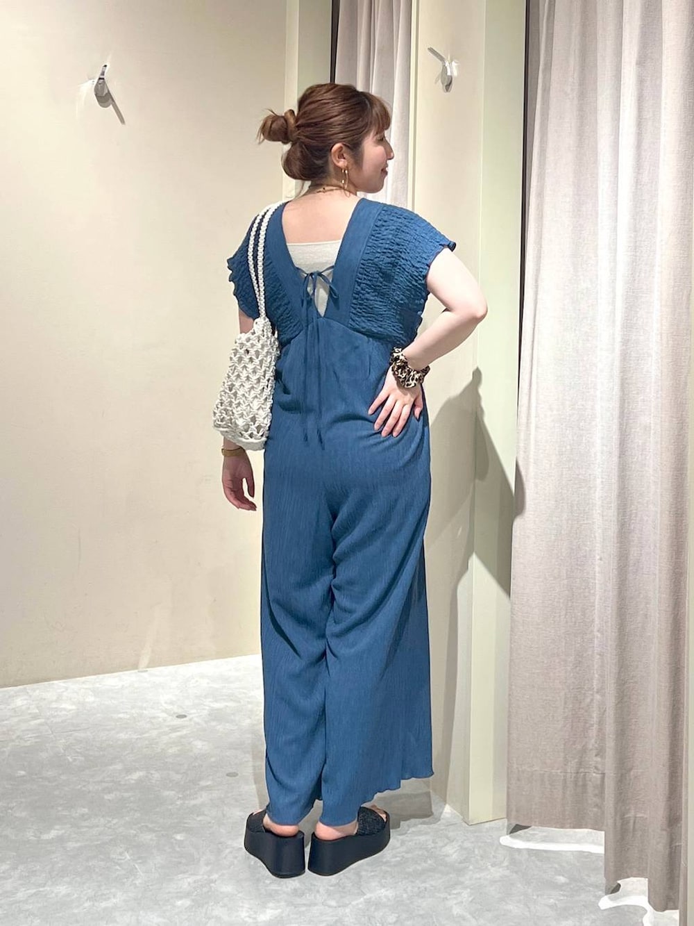 ブラック系のサンダル、ホワイト系のトートバッグ、シルバー系のタンクトップを着用したレディースの夏コーディネートの3枚目の写真