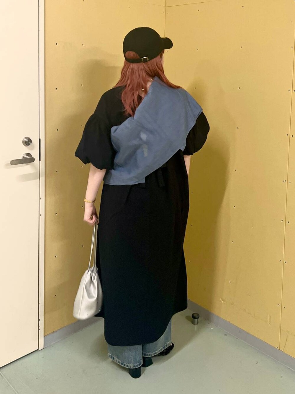 ブラック系のワンピース、シルバー系のショルダーバッグ、ブルー系のデニムパンツを着用したレディースの夏コーディネートの3枚目の写真