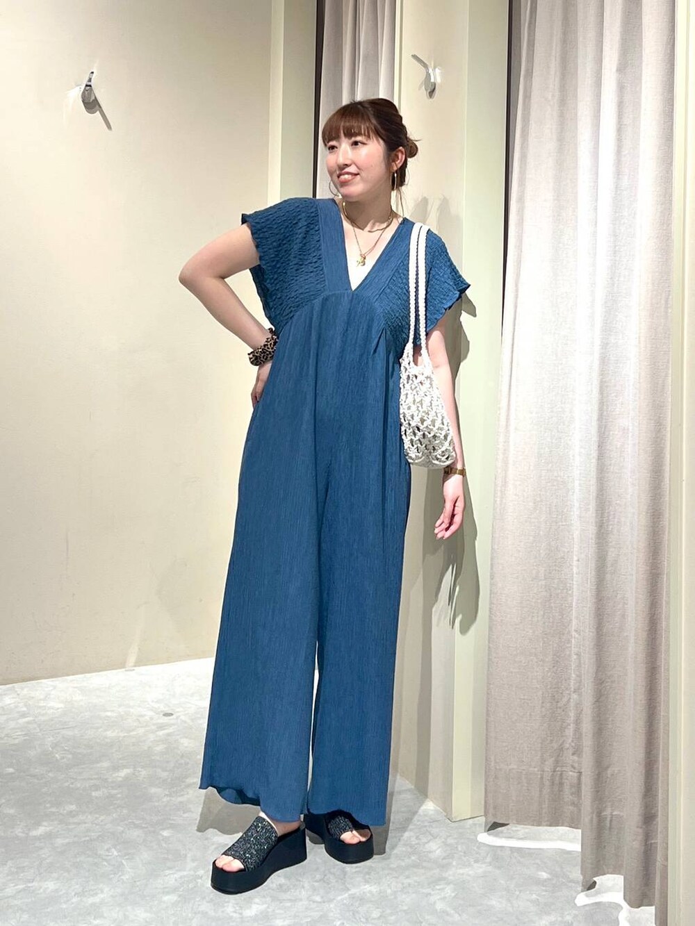 ブラック系のサンダル、ホワイト系のトートバッグ、シルバー系のタンクトップを着用したレディースの夏コーディネートの4枚目の写真