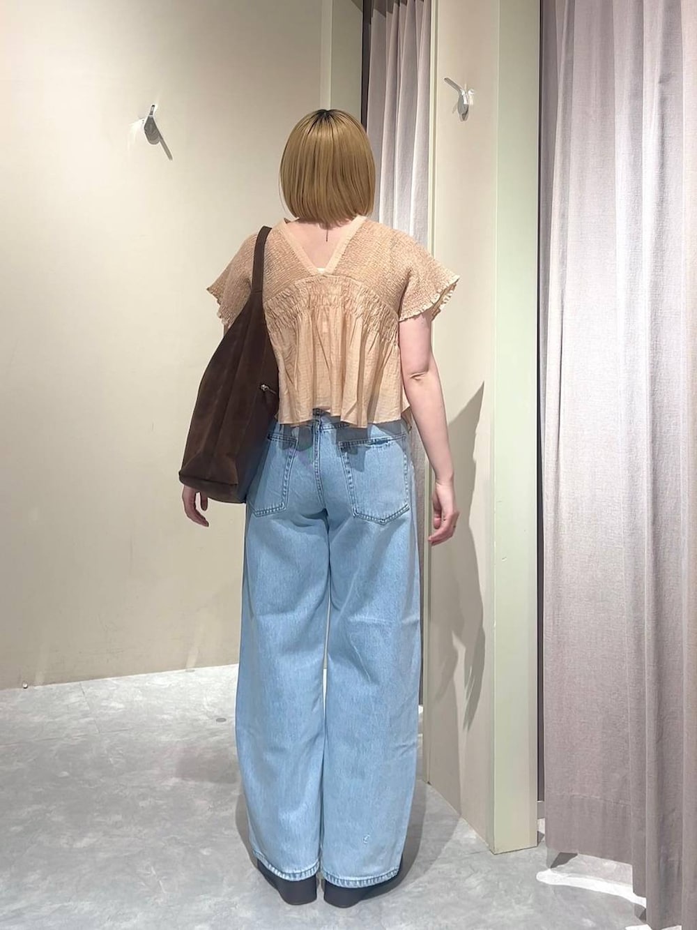 ブラウン系のショルダーバッグ、ブルー系のデニムパンツ、ブラウン系のサンダルを着用したレディースの春コーディネートの3枚目の写真