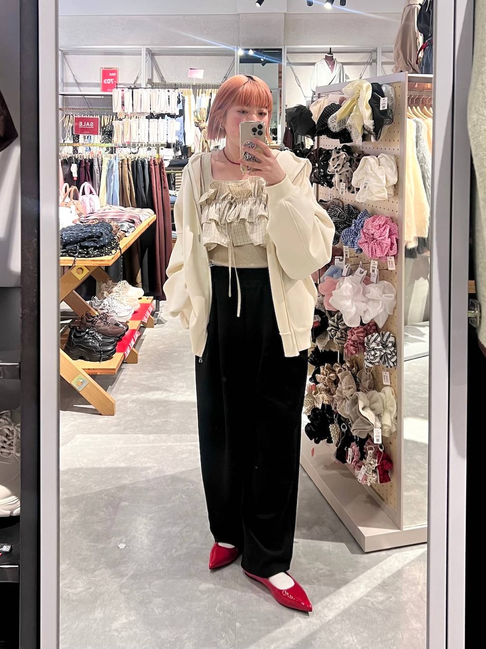 ブラック系のスウェットパンツ、ゴールド系のタンクトップ、ベージュ系のパーカーを着用したレディースの冬コーディネートの5枚目の写真