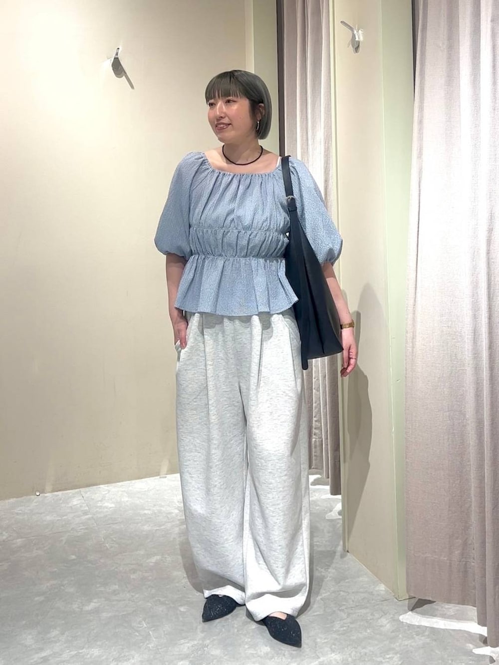 ブラック系のショルダーバッグ、グレー系のスウェットパンツ、ブラック系のパンプスを着用したレディースの春コーディネートの5枚目の写真