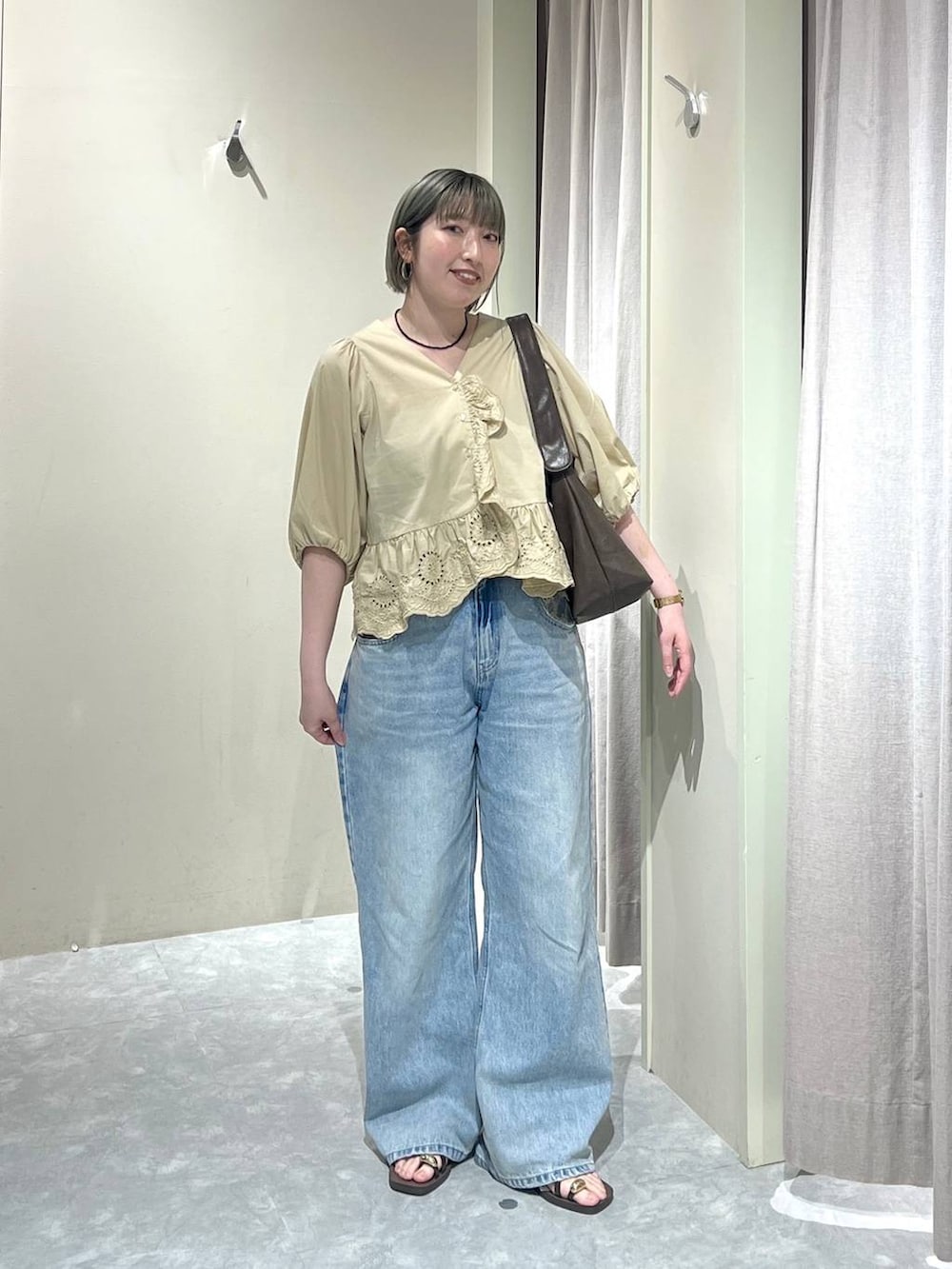 ブルー系のデニムパンツ、ブラウン系のサンダル、ベージュ系のシャツ/ブラウスを着用したレディースの春コーディネートの9枚目の写真