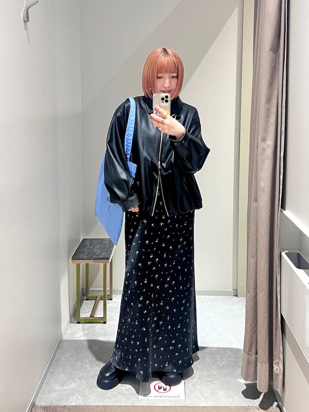 ブラック系のスカート、ブラック系のサンダル、ブルー系のトートバッグを着用したレディースの冬コーディネートの3枚目の写真