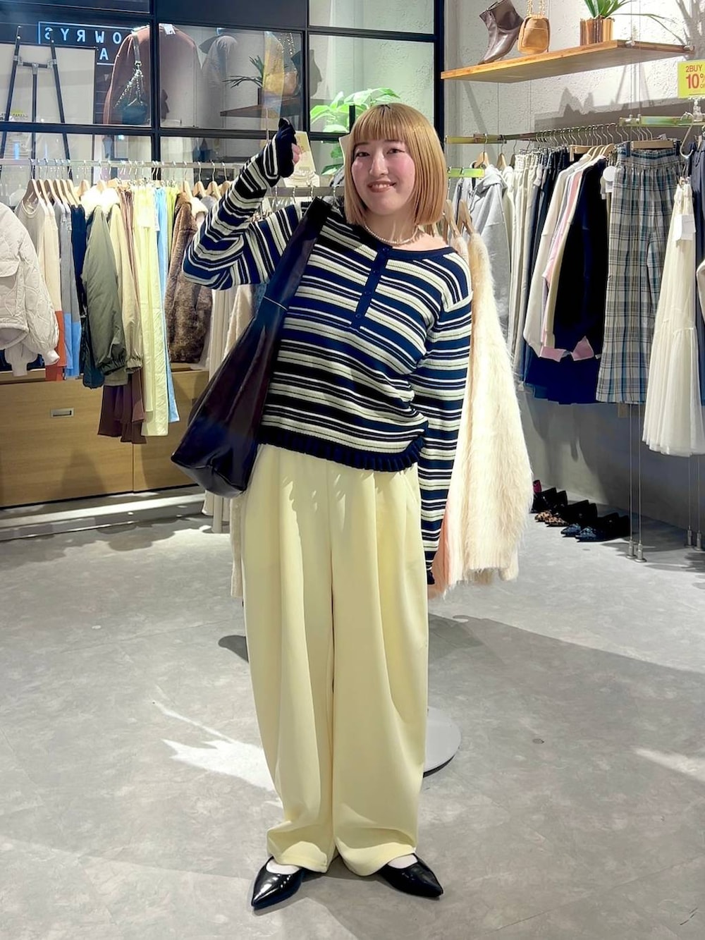 イエロー系のスウェットパンツ、ブラック系のパンプス、ブラウン系のショルダーバッグを着用したレディースの冬コーディネートの5枚目の写真