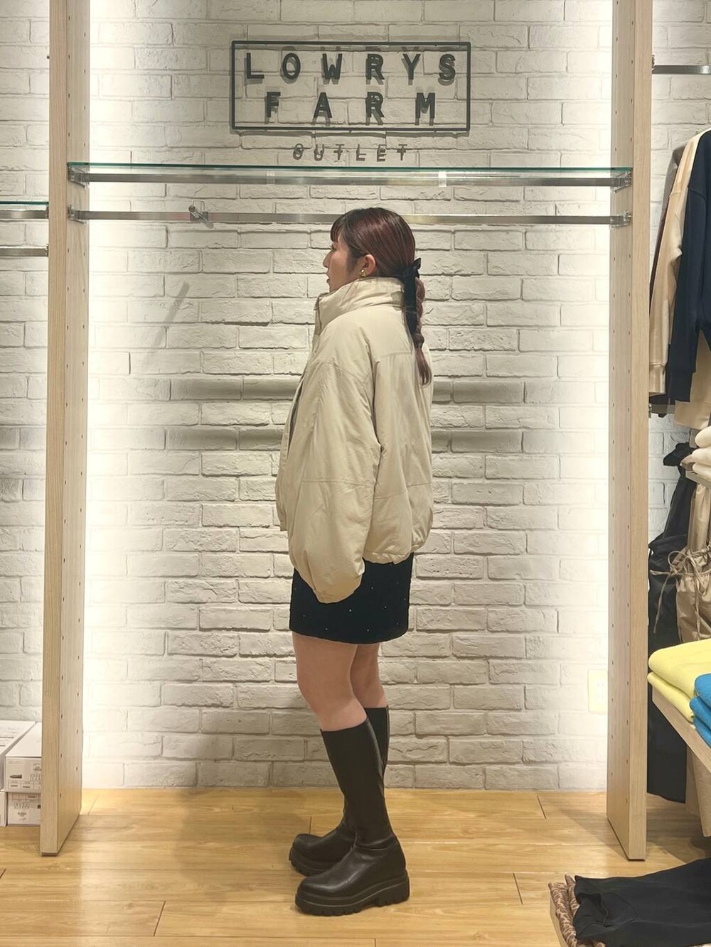 ホワイト系のその他アウター、ブラック系のブーツ、ブラック系のスカートを着用したレディースの冬コーディネートの2枚目の写真