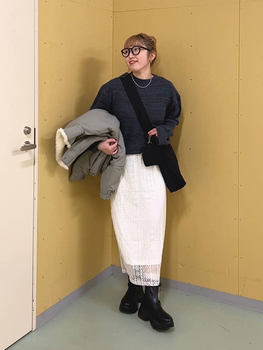 ブラック系のブーツ、ブルー系のワンピース、グリーン系のブルゾンを着用したレディースの冬コーディネートの7枚目の写真