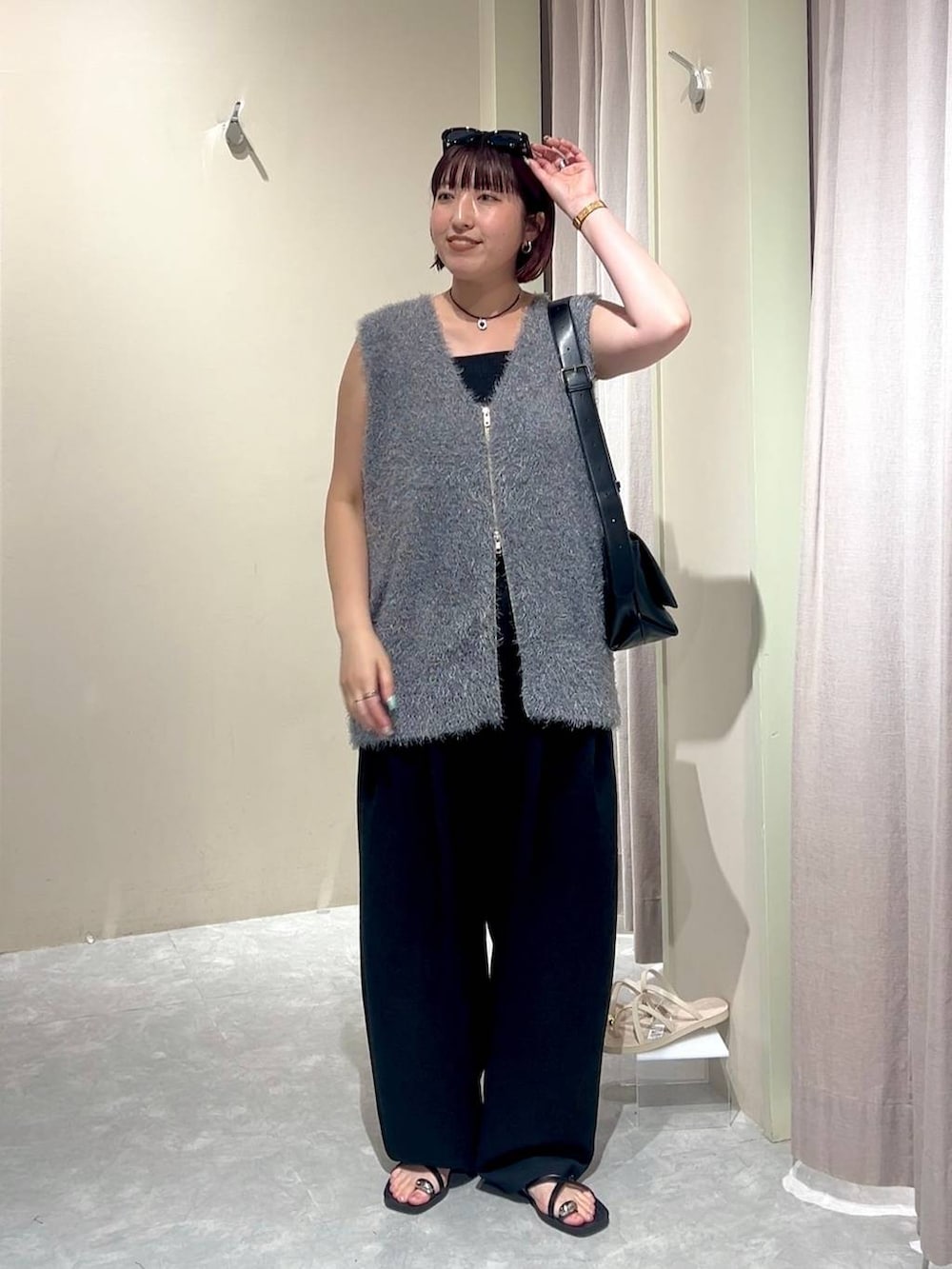 ブラック系のショルダーバッグ、ブラック系のスウェットパンツ、ブラック系のタンクトップを着用したレディースの秋コーディネートの5枚目の写真