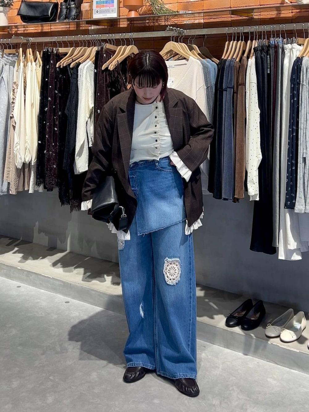 ブラック系のショルダーバッグ、ブルー系のデニムパンツ、ホワイト系のニット/セーターを着用したレディースの秋コーディネートの4枚目の写真